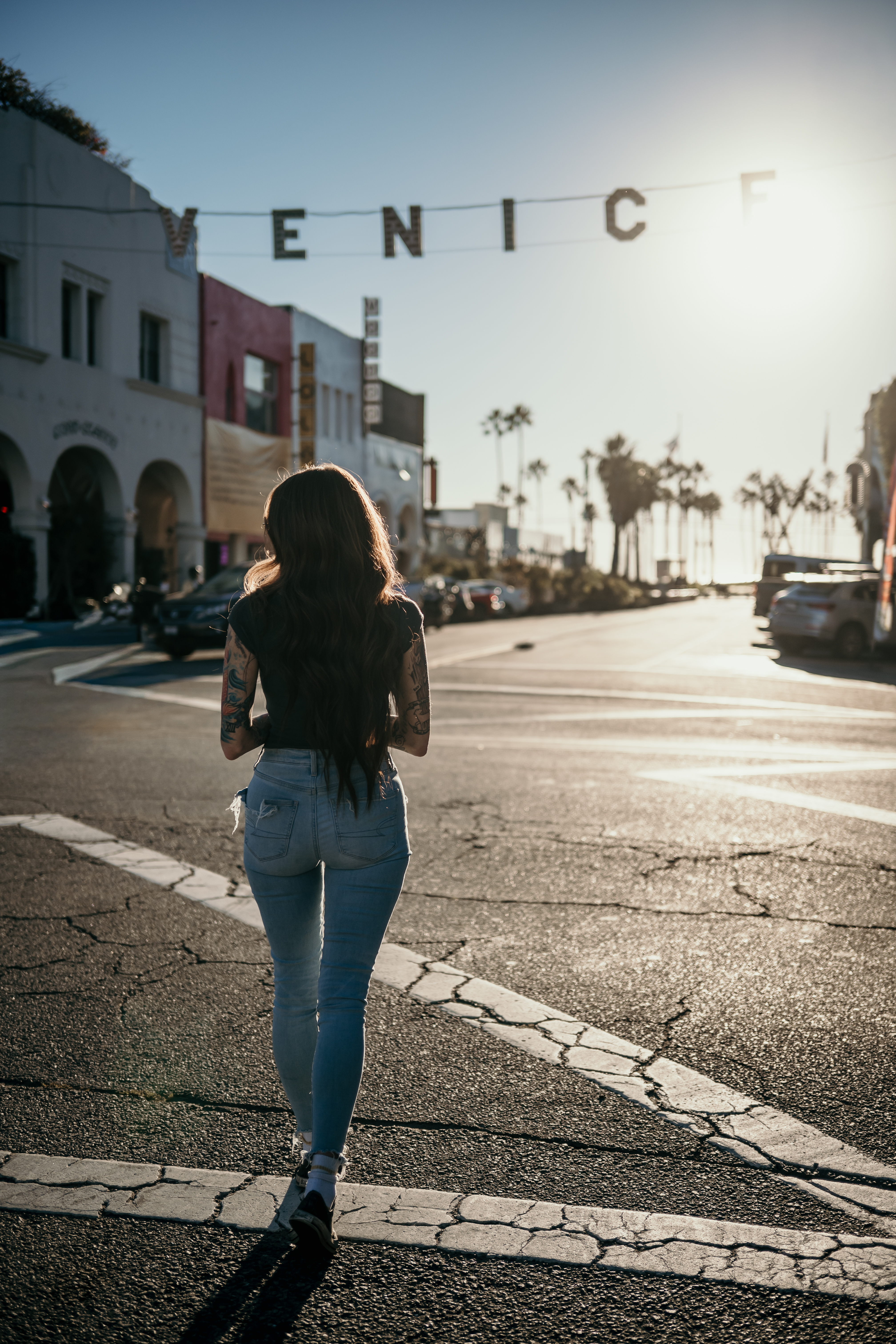 Walking beneath the Venice sign in California